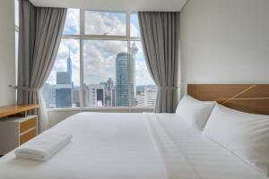 a bedroom with a large bed with a large window at Sky Suites KLCC By Elite Stay in Kuala Lumpur