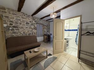 ein Wohnzimmer mit einer Couch und einer Steinwand in der Unterkunft Studieux in Millau