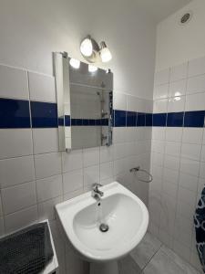 ein weißes Badezimmer mit Waschbecken und Spiegel in der Unterkunft Studieux in Millau