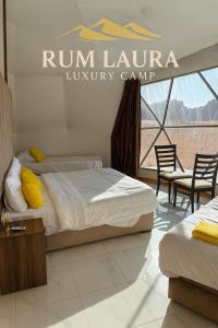 Dos camas en una habitación con un letrero de Run Lauren Luxury Camp en Rum Laura luxury camp, en Wadi Rum