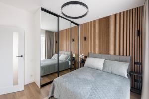 une chambre avec un lit et un miroir dans l'établissement Cottage Luxe Žaliakalnis, à Kaunas
