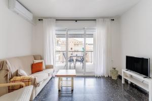 a living room with a couch and a tv at Mar 4 en Santa Pola in Santa Pola