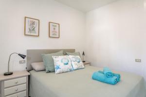 a bedroom with a bed with blue towels on it at Mar 4 en Santa Pola in Santa Pola +18 photos