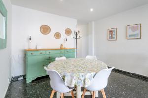 a dining room with a green table and white chairs at Mar 4 en Santa Pola in Santa Pola