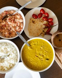 einen Tisch mit Schalen mit Essen und Reis in der Unterkunft Villa 1818 - Wellawaya in Wellawaya + 7 Fotos