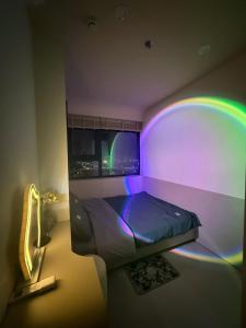 une chambre avec un lit illuminé par une lumière arc-en-ciel dans l'établissement Châu Giang Luxury -Nera Garden APartment 2-3 Bedroom, FREE hồ bơi, à Hue