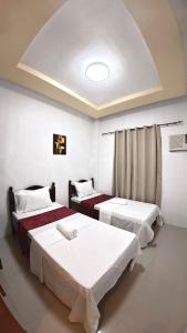 プエルト・プリンセサにあるCozy Stop Inn - Puerto Princesaの部屋にベッドが3つある部屋