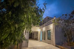 a white building with a tree in the foreground at Rose In Apartment in Wadi Musa