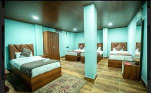 Großes Zimmer mit 2 Betten und einem Sofa in der Unterkunft Padmashree Hotel & Spa in Darjeeling + 3 Fotos