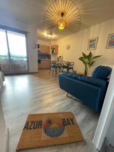 ein Wohnzimmer mit einem blauen Sofa und einem Tisch in der Unterkunft Azur Bay Boho-Chic T2 Garage & Mer Pet-Friendly in La Ciotat