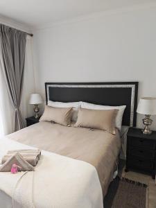 - une chambre avec 2 lits et 2 tables de nuit avec des lampes dans l'établissement Somerset West Stay 2, à Somerset West