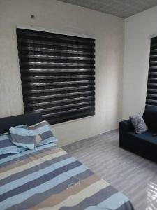 une chambre avec un lit, un canapé et une fenêtre dans l'établissement Guest Apartments, à New Weija