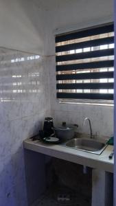 un comptoir de cuisine avec un évier et une fenêtre dans l'établissement Guest Apartments, à New Weija 5 autres photos