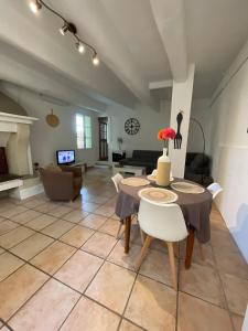 a living room with a table and chairs and a fireplace at Gîte au cœur des vignes, près du canal du Midi in Capestang