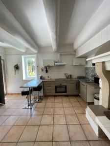 a large kitchen with a table in the middle at Gîte au cœur des vignes, près du canal du Midi in Capestang