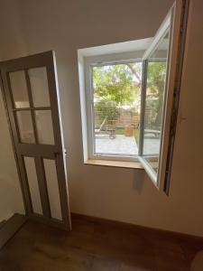 an empty room with a window and a door at Gîte au cœur des vignes, près du canal du Midi in Capestang