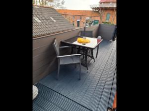 een balkon met een tafel en stoelen op een dak bij NEU! Ferienstübchen Julian ZWEI mit Whirlpool in Greetsiel