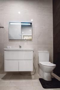 une salle de bain avec toilettes, lavabo et miroir dans l'établissement АПАРТАМЕНТЫ МОРЕе, à Odessa 8 autres photos