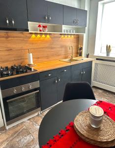 a kitchen with a table and a sink and a stove at Old town loft - apartment in the old town Craiova in Craiova +17 photos