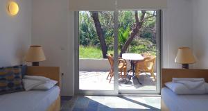 a bedroom with a door open to a patio with a table at Proimos Apartments in Gerani
