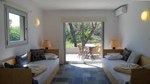 a living room with two beds and a patio at Proimos Apartments in Gerani