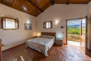 a bedroom with a bed and a large window at Tenuta La Chiusa in Portoferraio