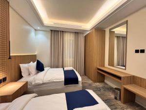 a hotel room with two beds and a mirror at فندق ارجان بارك جدة in Jeddah