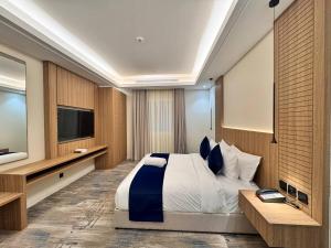 a bedroom with a large bed and a flat screen tv at فندق ارجان بارك جدة in Jeddah