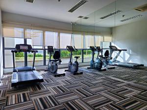 a gym with tread machines and a large window at Country Garden Danga Bay By Widebed JB in Johor Bahru
