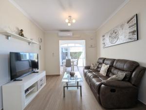 een woonkamer met een bank en een flatscreen-tv bij R-66-A-B Pisos La Mata in La Mata