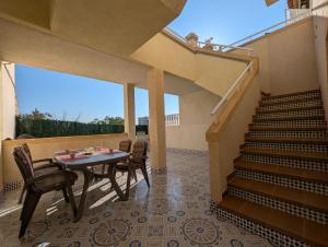 een patio met een tafel, stoelen en een trap bij R-66-A-B Pisos La Mata in La Mata