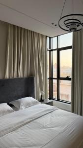 ein Schlafzimmer mit einem Bett und einem großen Fenster in der Unterkunft سكاي هوم السلامة in Dschidda