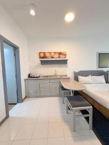 a bedroom with a bed and a table and a sink at Rainbow Paradise BeachFront Penang in Tanjung Bungah