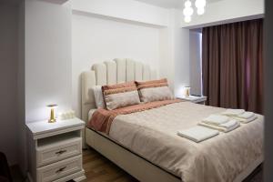 een witte slaapkamer met een groot bed met handdoeken erop bij Apartament de închiriat Accommodation Ap 9 in Suceava