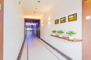 a corridor in a building with potted plants at FabHotel Devanshi Inn in Kalamboli