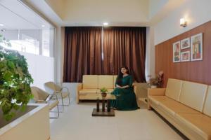 a woman is sitting in a waiting room at FabHotel Devanshi Inn in Kalamboli