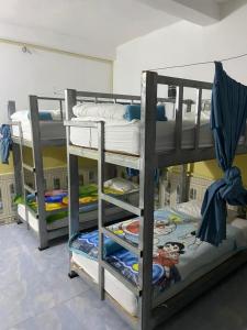 a bunk bed with three bunk beds in a room at Mekong Backpackers 2 PB in Pakbeng