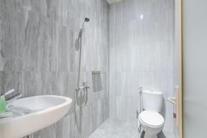 a bathroom with a toilet and a sink and a shower at Urbanview Hotel Brodam's Pematang Siantar by RedDoorz in Pematangsiantar +34 photos