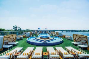 a deck of a cruise ship with chairs and a pool at Sonesta St George Nile Cruise - Luxor to Aswan 4 Nights from Monday to Friday in Luxor