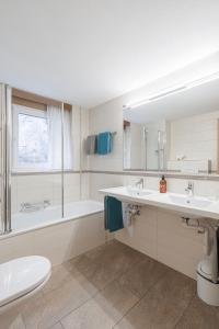 a bathroom with two sinks and a tub and a toilet at Bolero Appartements in Zermatt +89 photos