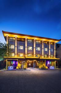 a large building with a lit up facade at night at Honglu Garden Hotel Bell and Drum Tower Huimin Street Store & 2 bottles of beer for free in Xi'an