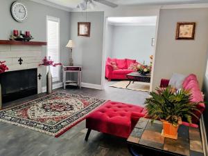 ein Wohnzimmer mit einem roten Sofa und einem Kamin in der Unterkunft The Denham Springs Esape- Pool, Comfort & Charm in Denham Springs