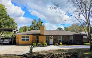 ein gelbes Haus mit einer Garage in der Unterkunft The Denham Springs Esape- Pool, Comfort & Charm in Denham Springs