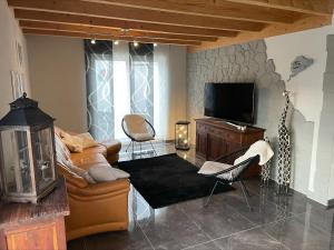 a living room with a couch and a television at Wellness-Villa-Eifel 3 Schlafzimmer in Mechernich