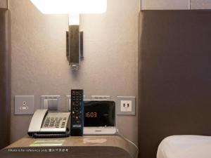 a room with a desk with a phone and a clock at Royal Plaza Hotel in Hong Kong