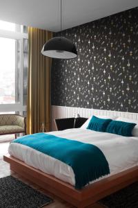 瓦尔帕莱索阿斯托雷卡宫酒店的卧室里有一张大床，上面铺着蓝色毯子