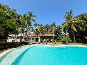 a large swimming pool in front of a house at Sandbox in Kilifi