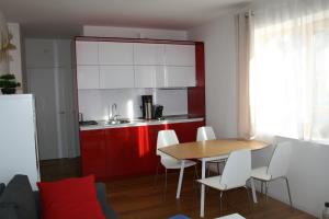 a kitchen with a wooden table and white chairs at Modernes Apartment - Nockberge in Ebene Reichenau +29 photos