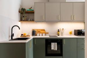 a kitchen with green cabinets and a sink at Relaxed, Spacious & Ideal for Small Families in Bournemouth