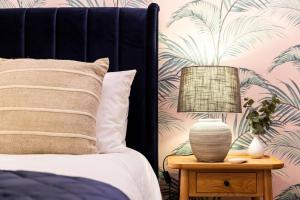 a bedroom with a bed with a table with a lamp at Relaxed, Spacious & Ideal for Small Families in Bournemouth +4 photos